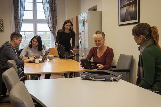 Verschiedene Menschen unterhalten sich in einem Büro.