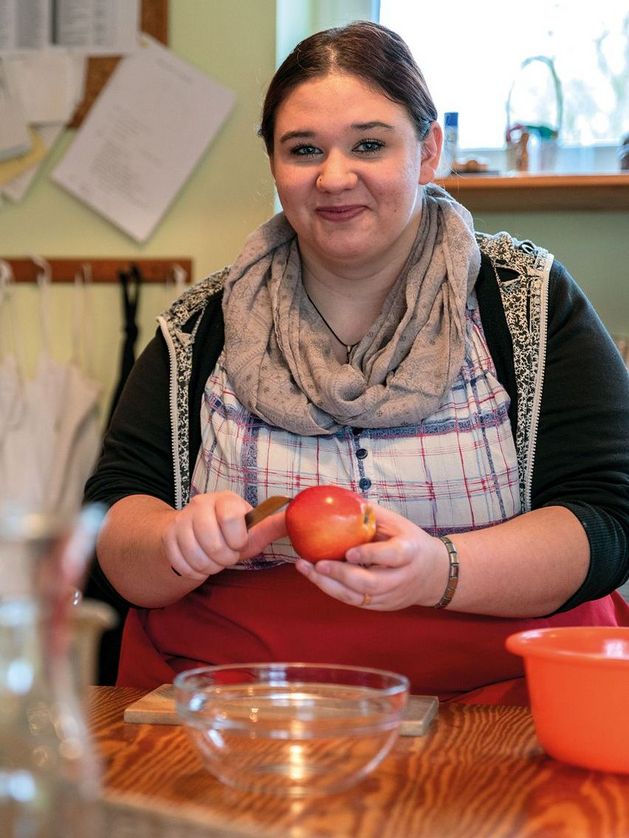 Eine Person arbeitet am Küchentisch.