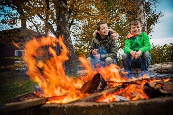 am Lagerfeuer sitzen Kinder und lachen