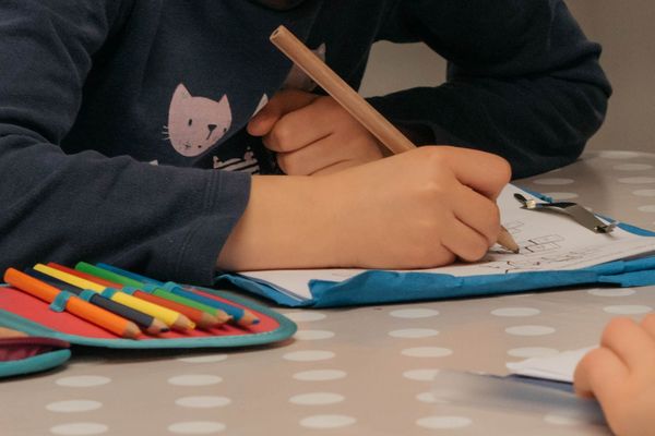 eine Kinderhand hält einen Stift und schreibt