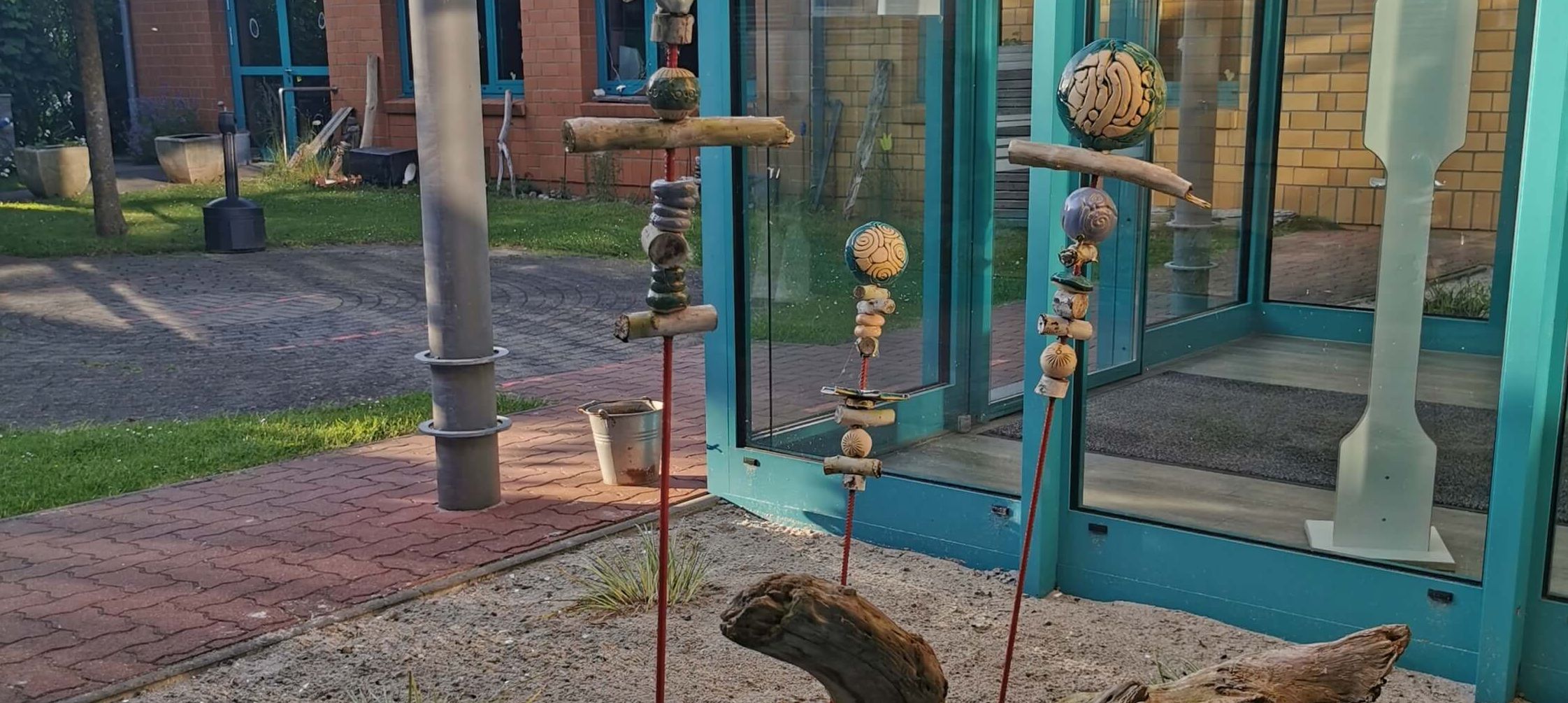 Skulpturen aus Naturmaterialien vor einem Gebäude