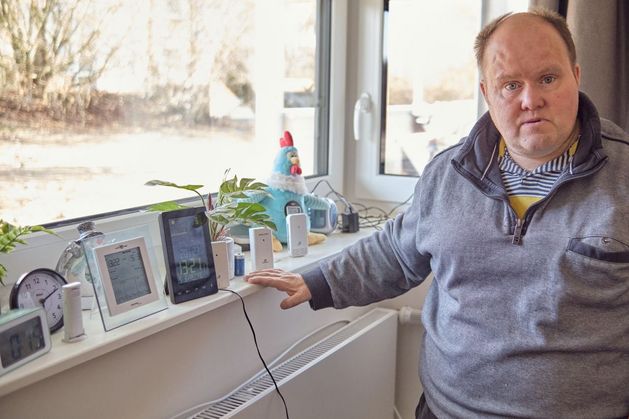 Eine Person am Fenster mit verschiedenen Gegenständen auf der Fensterbank.