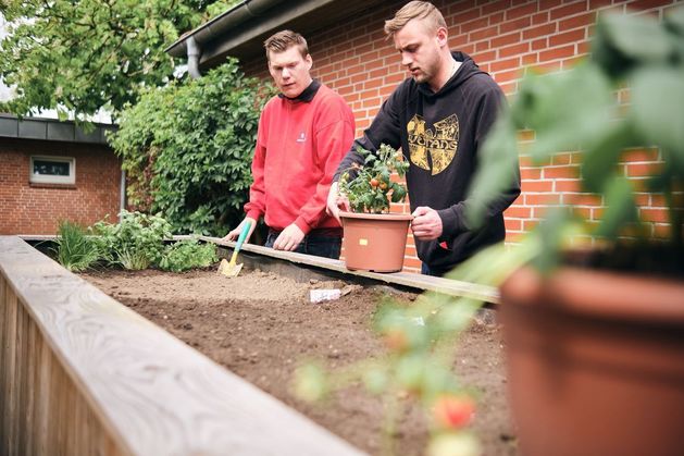 Gemeinsame Arbeit im Garten an einem Hochbeet.