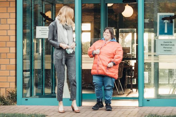 zwei Personen verlassen ein Gebäude