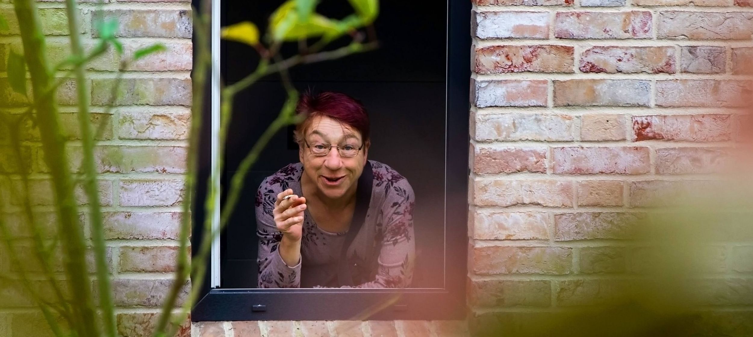 Eine Person schaut aus dem Fenster heraus