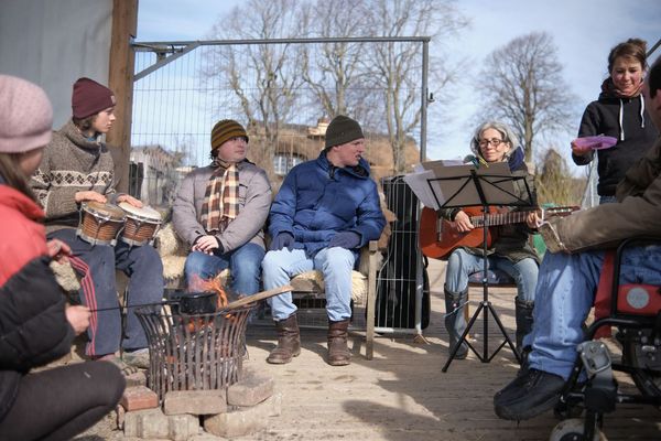 Menschen sitzen zusammen und machen Musik.