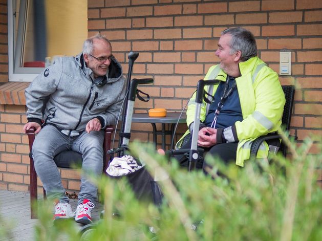 Zwei Leute sitzen auf der Bank und unterhalten sich.