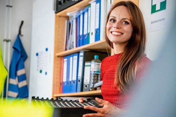 eine Person in einem Büro hält etwas in der Hand und lacht