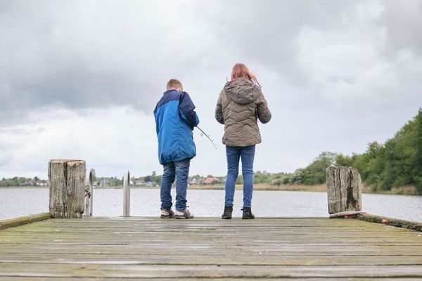 zwei Kinder angeln auf einem Steg an der Schlei